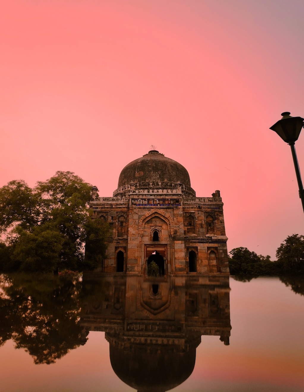 Monument in Hauz Khas under a pink sky in Delhi, India